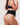Woman wearing the BZEZ Mid Fit Control Thong in Onyx (black), back view