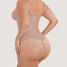 Woman wearing the BZEZ Smoothing Sculpt Bodysuit Thong in Bare, back view