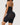Woman wearing the BZEZ Smoothing Sculpt Bodysuit Shorts in Onyx (black), back view